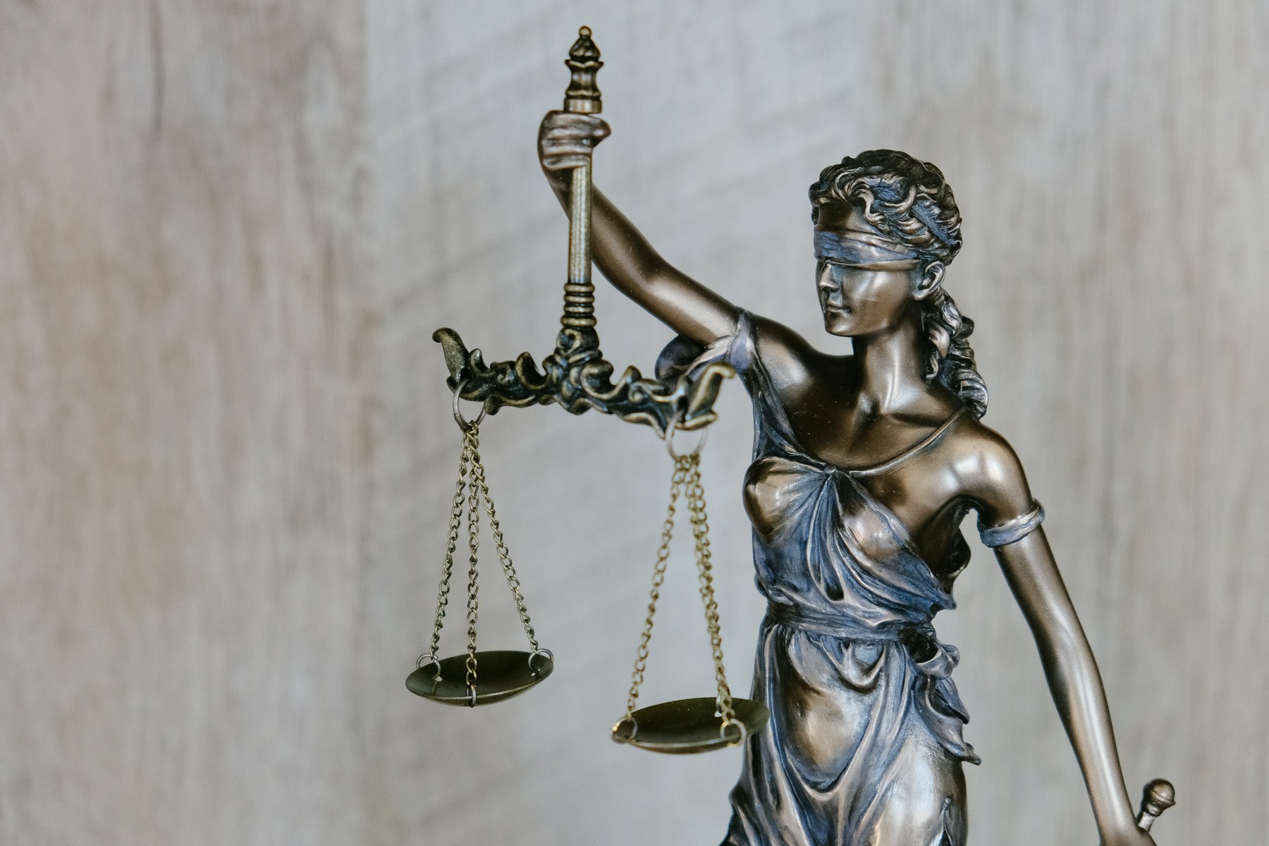 Estátua da Justiça com balança em primeiro plano